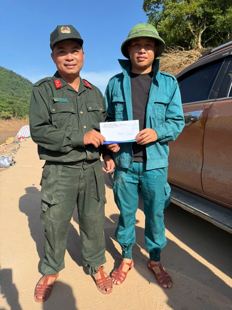Lực lượng Dân quân tự vệ xã Nhôn Mai thay mặt gia đình có người lũ cuốn trôi trên địa bàn xã nhận món quà 2 triệu đồng của Lãnh đạo Phòng Cảnh sát cơ động trao tại điểm dạ chiến của Nhôn Mai lập tại bản Xốp Tụ, xã Mỹ Lý