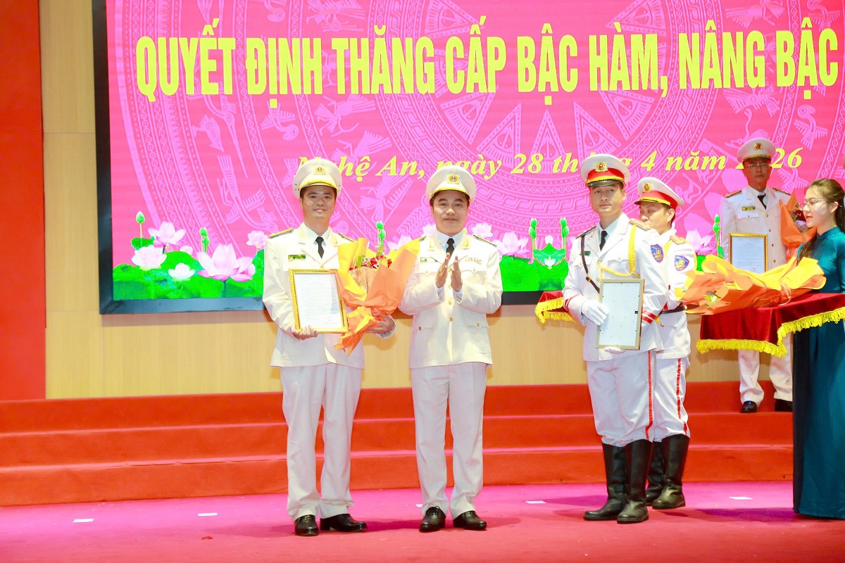 Đồng chí Đại tá Nguyễn Huy Khích, Phó Giám đốc Công an tỉnh trao quyết định, tặng hoa chúc mừng các đồng chí được thăng cấp bậc hàm Thượng tá