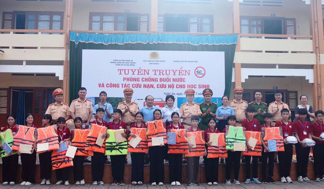 Đại biểu trao áo phao, mũ bảo hiểm, cuốn vở và dụng cụ nổi tặng học sinh