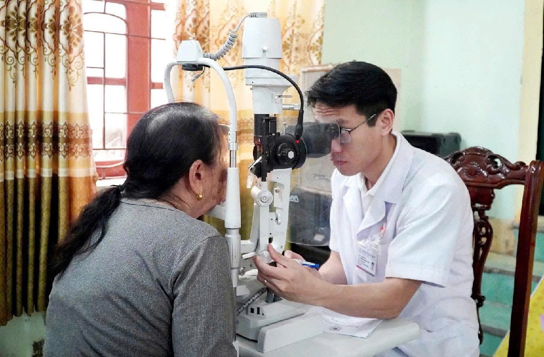 Bác sĩ khám bệnh lý về mắt cho người dân