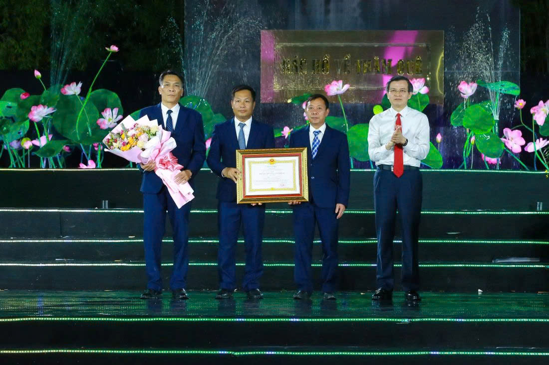 Đồng chí Đoàn Minh Huấn - Ủy viên Bộ Chính trị, Giám đốc Học viện Chính trị Quốc gia Hồ Chí Minh trao Huân chương Lao động hạng Nhất và tặng hoa đến tập thể lãnh đạo Khu Di tích Quốc gia đặc biệt Kim Liên