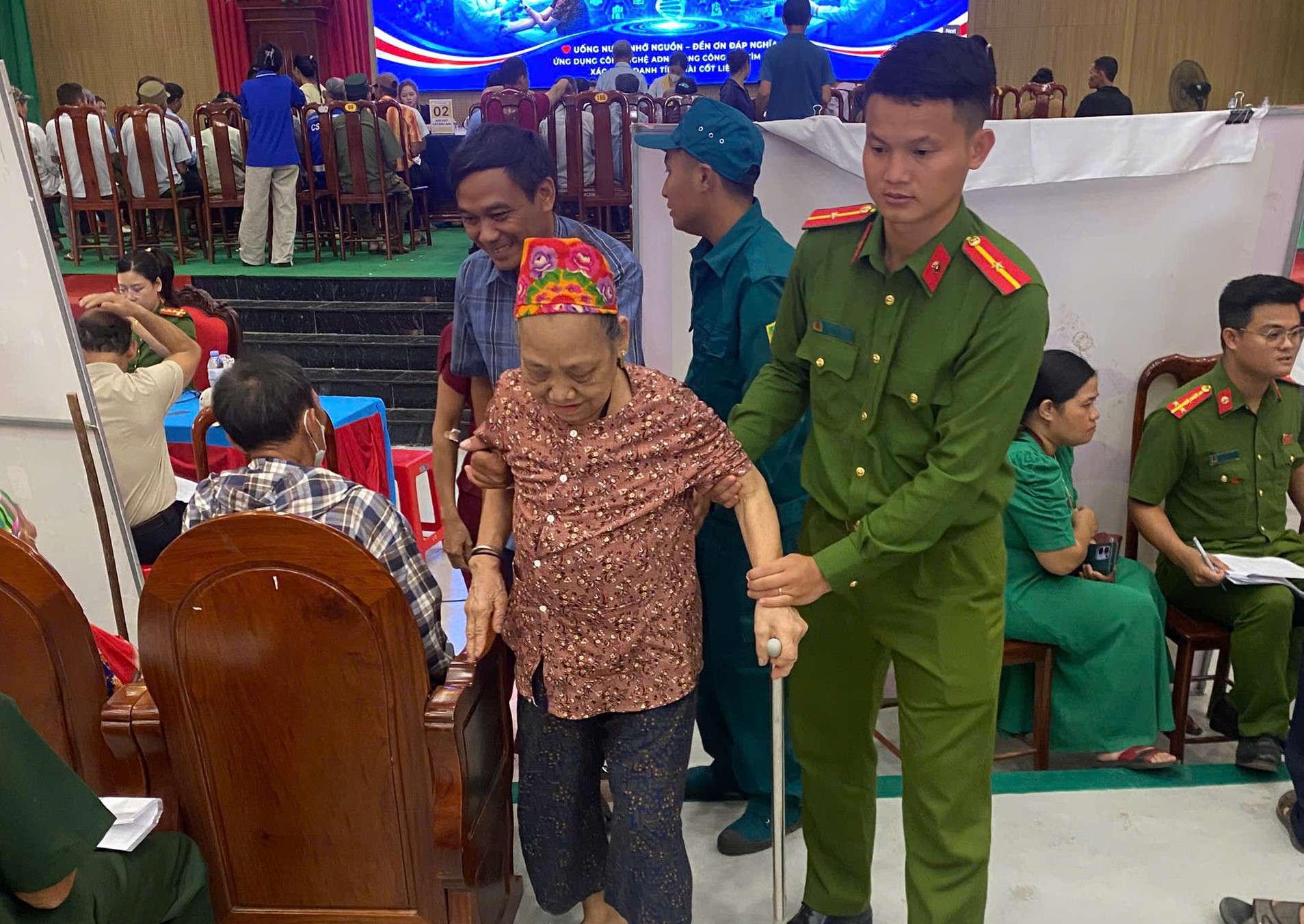 Công an xã  hướng dẫn, hỗ trợ thân nhân các gia đình liệt sĩ đến điểm thu nhận mẫu AD
