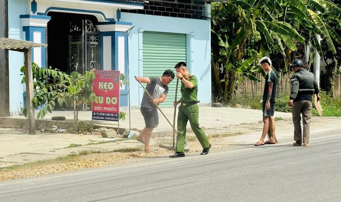 Công an xã Nghĩa Khánh dọn dẹp đất đá rơi vãi trên đường